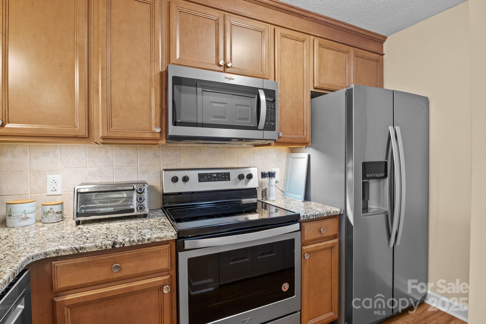 18009 Kings Point Drive, Unit I Cornelius, NC 28031 - Photo 8 of 47 a kitchen with granite countertop cabinets stainless steel appliances and a counter space