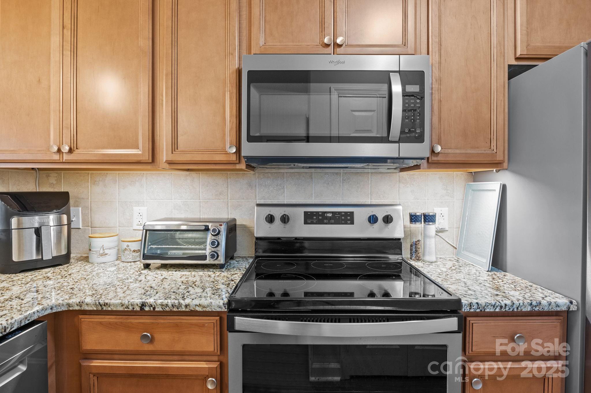 18009 Kings Point Drive, Unit I Cornelius, NC 28031 - Photo 9 of 47 a kitchen with granite countertop a stove and a microwave