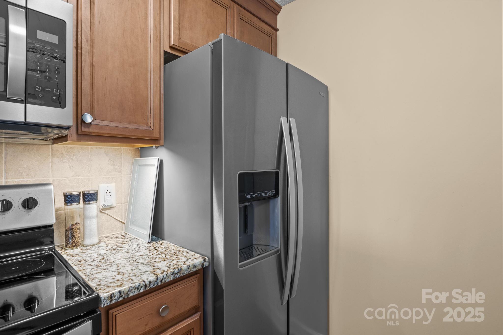 18009 Kings Point Drive, Unit I Cornelius, NC 28031 - Photo 10 of 47 a kitchen with stainless steel appliances granite countertop a refrigerator and a stove
