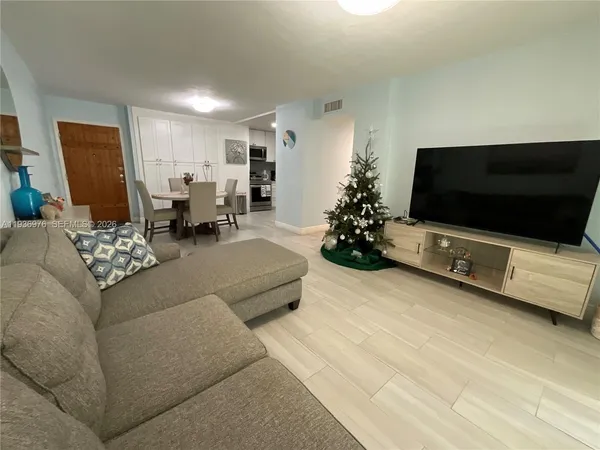 a living room with furniture flat screen tv and a window