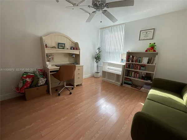 a view of a workspace with furniture and a window