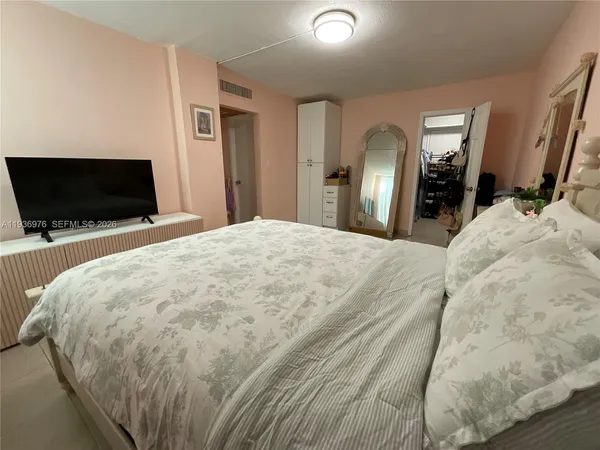 a spacious bedroom with a bed and a chandelier