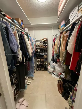 a spacious bedroom with a bed and a lamp