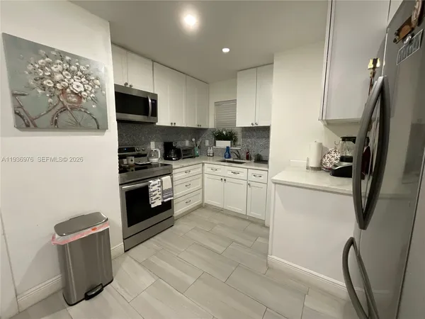 a kitchen with stainless steel appliances a refrigerator sink and microwave