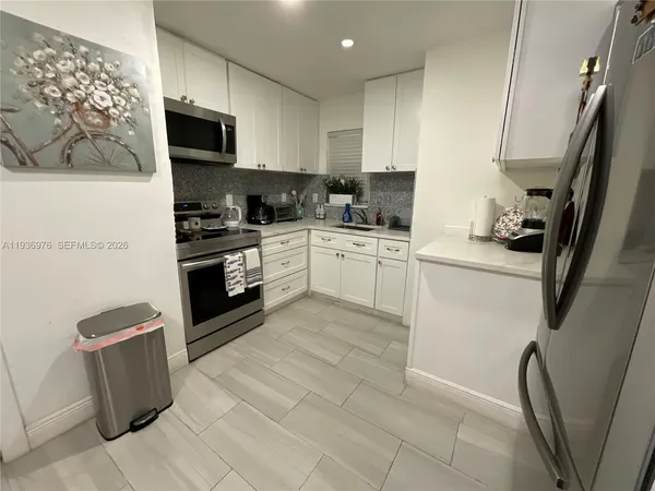 a kitchen with a sink a stove top oven a refrigerator and cabinets