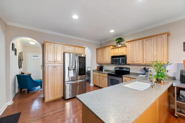 a kitchen with a refrigerator a sink dishwasher stove and oven