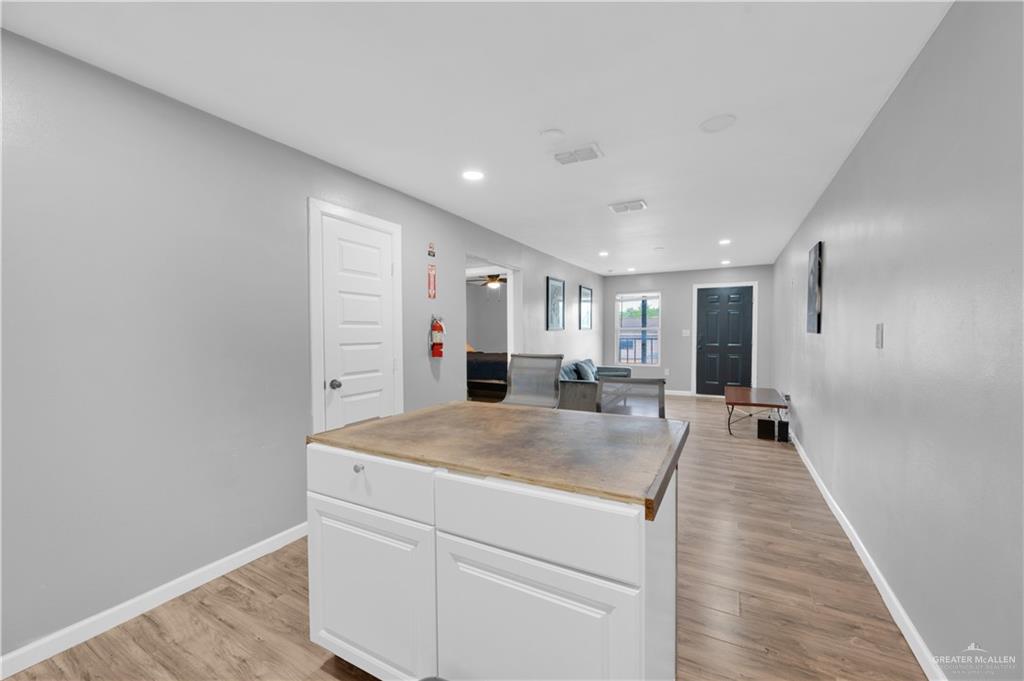 405 East Guerra Street Rio Grande City, TX 78582 - Photo 13 of 33 Kitchen with white cabinetry, light wood-style floors, a kitchen island, baseboards, and recessed lighting