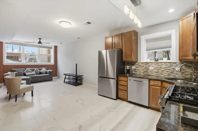 a kitchen with stainless steel appliances granite countertop a refrigerator and a stove