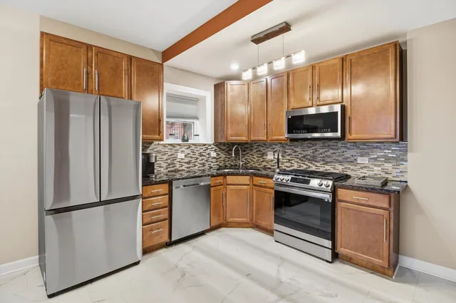 a kitchen with stainless steel appliances granite countertop a refrigerator a sink a stove a microwave and island