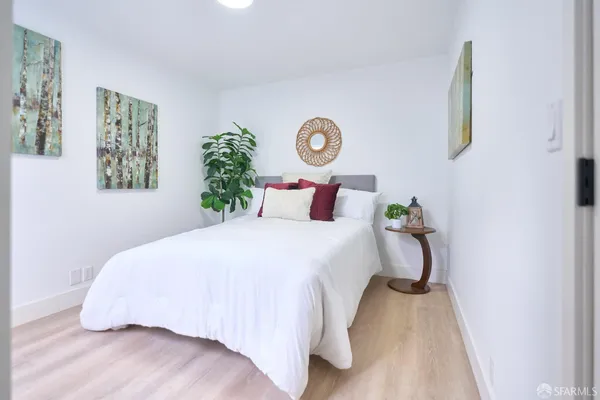 a bedroom with a bed and a potted plant