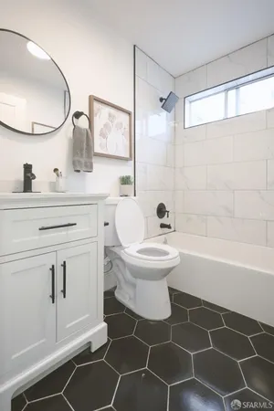 a bathroom with a toilet a sink and mirror
