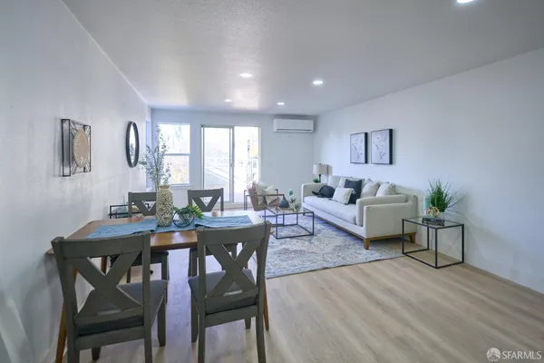 a living room with furniture a window and wooden floor