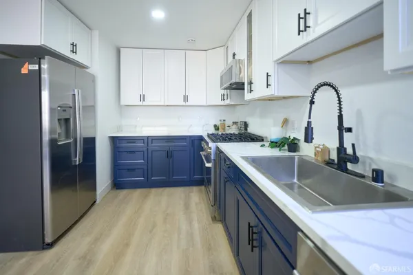 a kitchen with stainless steel appliances a stove a sink and cabinets