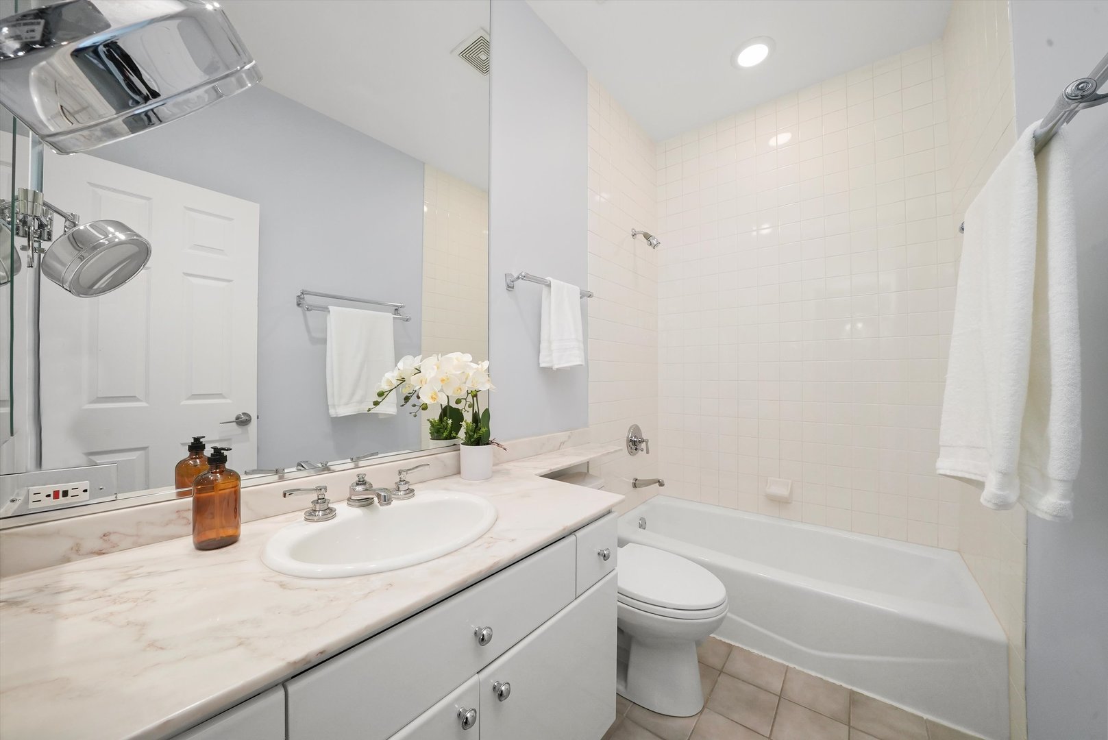 950 North Clark Street, Unit E Chicago, IL 60610 - Photo 32 of 52 a bathroom with a granite countertop sink and a mirror