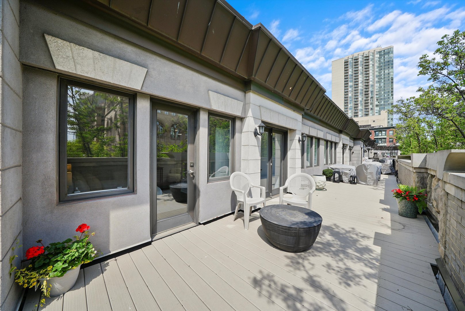 950 North Clark Street, Unit E Chicago, IL 60610 - Photo 49 of 52 a view of a patio with couches chairs potted plants and floor to ceiling window and wooden floor