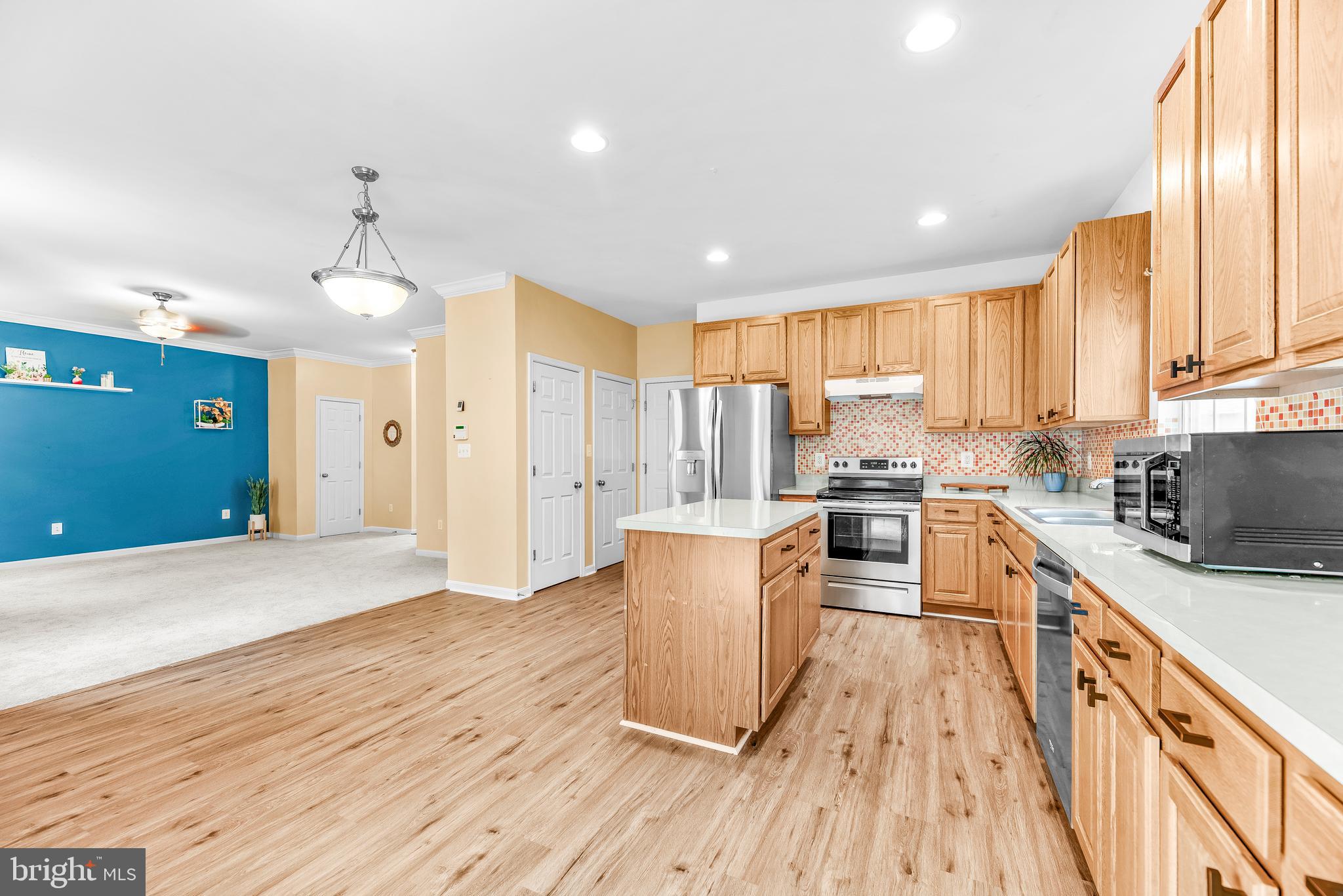 252 Rimfire Way Prince Frederick, MD 20678 - Photo 17 of 35 a kitchen with stainless steel appliances a stove top oven a sink dishwasher and a refrigerator with wooden floor