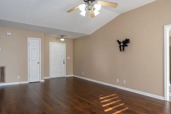 a view of an empty room with wooden floor