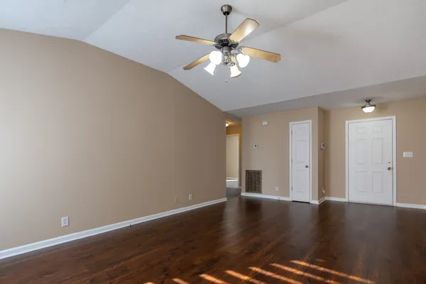a view of an empty room with wooden floor