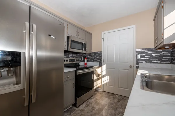 a view of kitchen with windows and refrigerator
