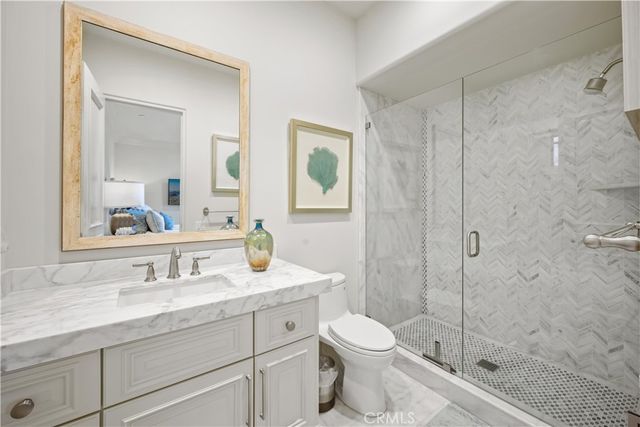 a bathroom with a granite countertop sink a toilet and shower