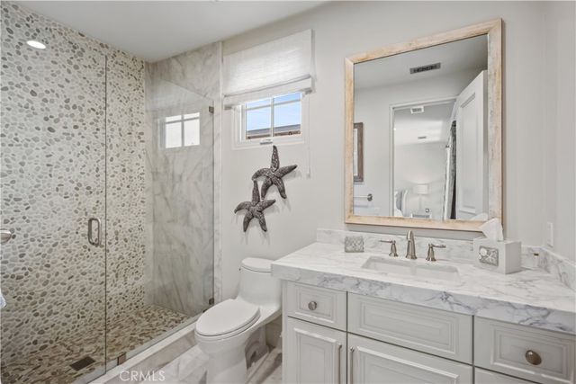 a bathroom with a granite countertop sink a toilet and a mirror