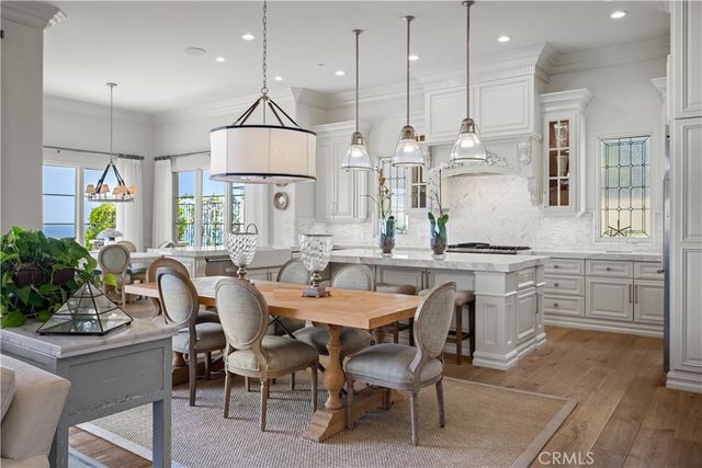 a very nice looking kitchen with granite countertop a table and chairs in it