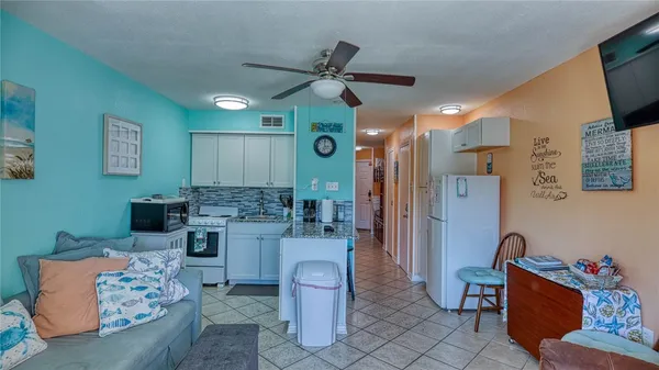 a kitchen with stainless steel appliances granite countertop a refrigerator a stove a sink and chairs