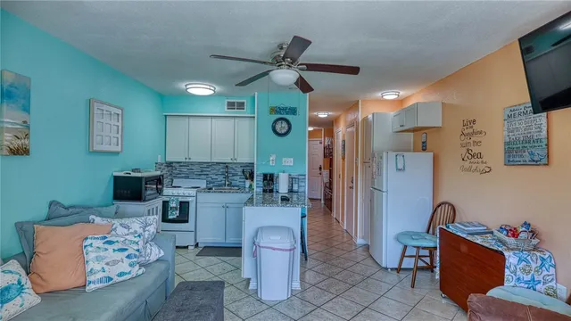 a kitchen with stainless steel appliances granite countertop a refrigerator a stove a sink and chairs