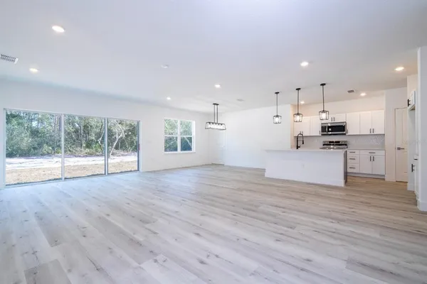 a view of kitchen with wooden floor and electronic appliances