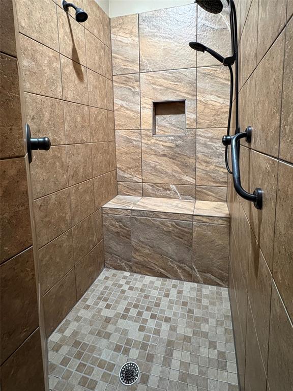 104 Adobe Cove Georgetown, TX 78633 - Photo 16 of 40 A generously sized walk-in shower features integrated seating and dual shower heads for ultimate comfort.
