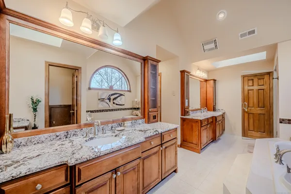 a hall with kitchen island a sink and a large mirror