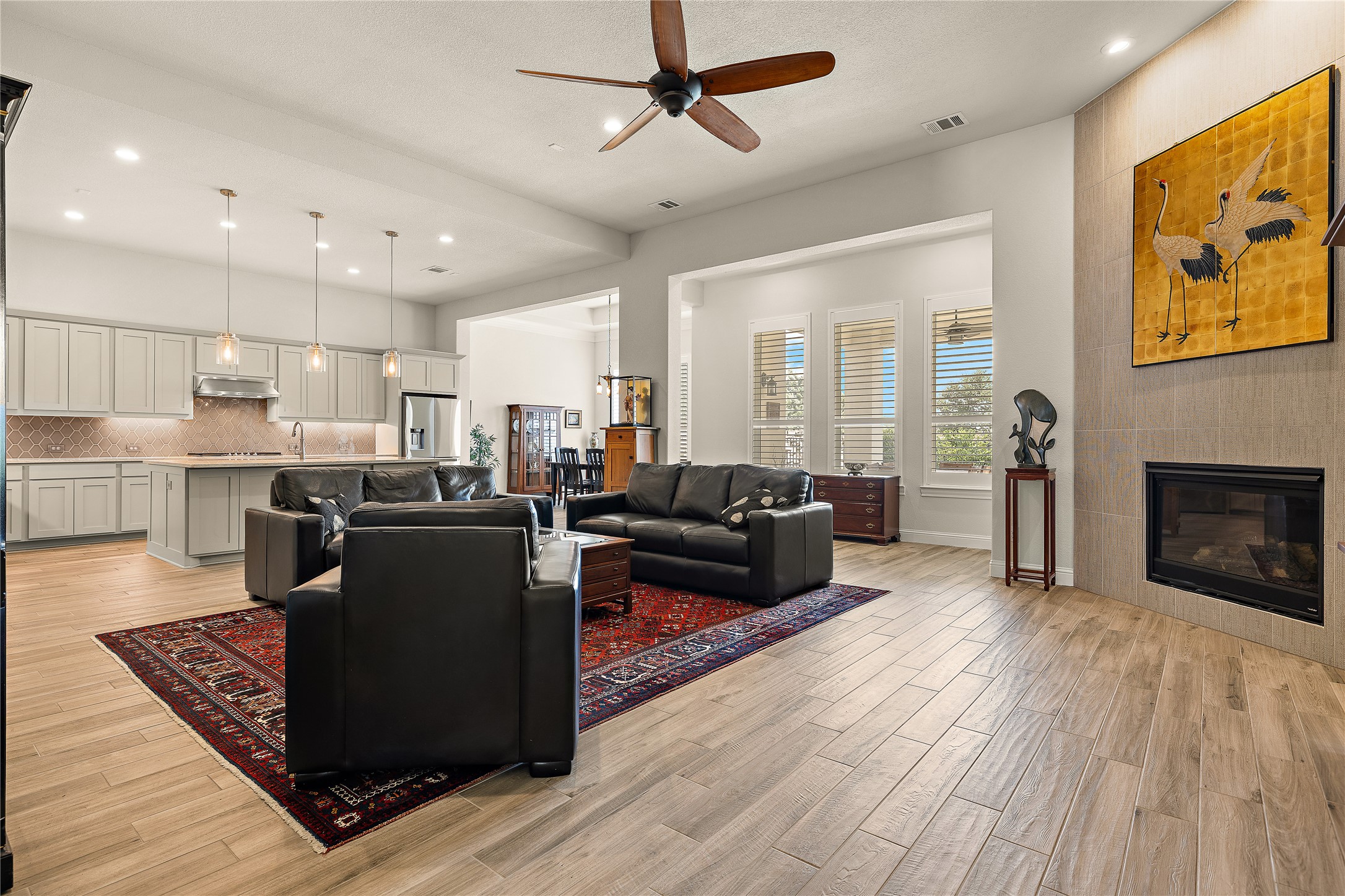 1716 Siena Sunset Road Leander, TX 78641 - Photo 10 of 28 The fireplace’s floor-to-ceiling tile surround gives this side of the living room its own foca point.