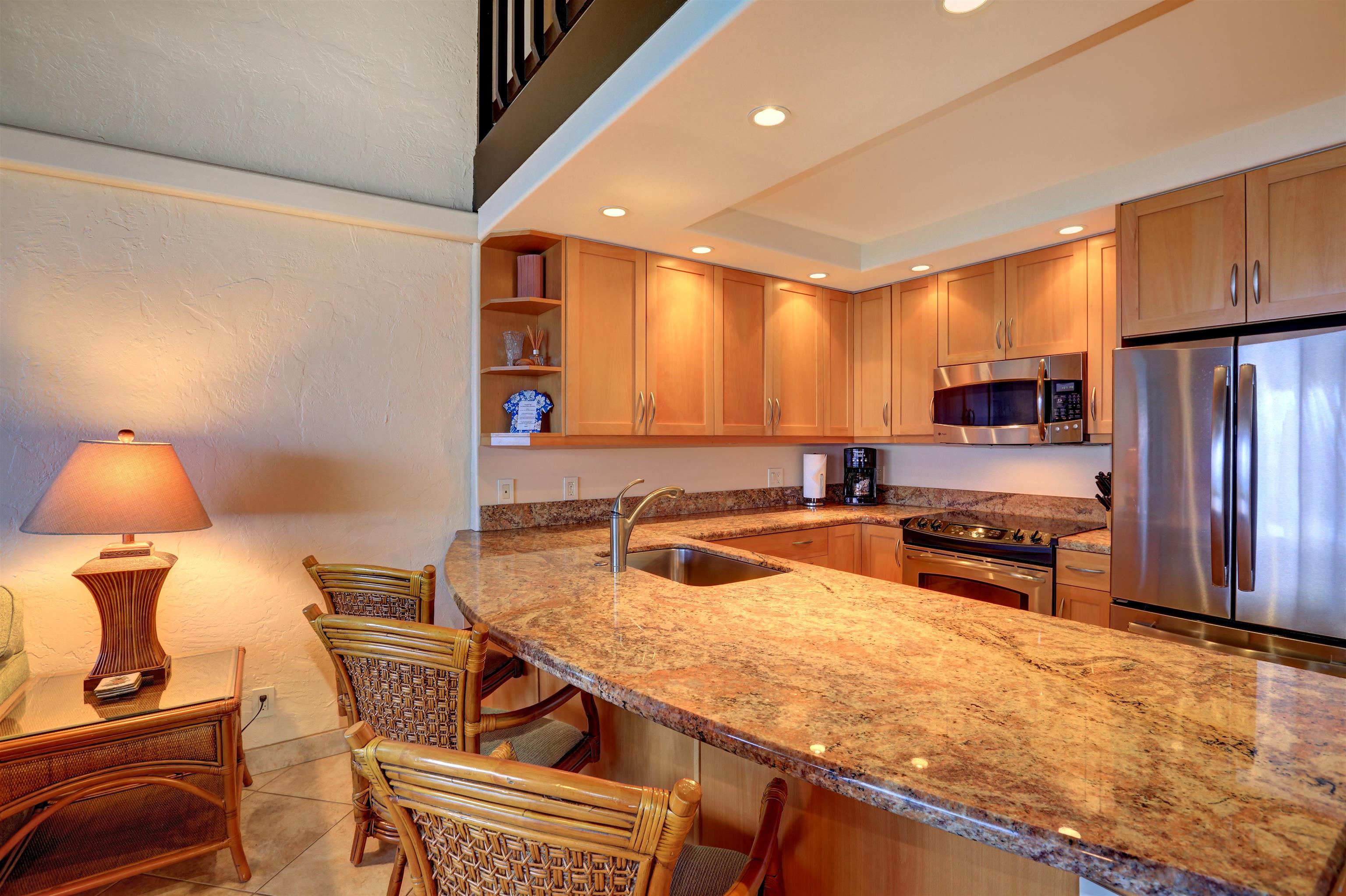 3543 Lower Honoapiilani Road, Unit K403 Lahaina, HI 96761 - Photo 2 of 29 a kitchen with stainless steel appliances granite countertop a sink and a refrigerator