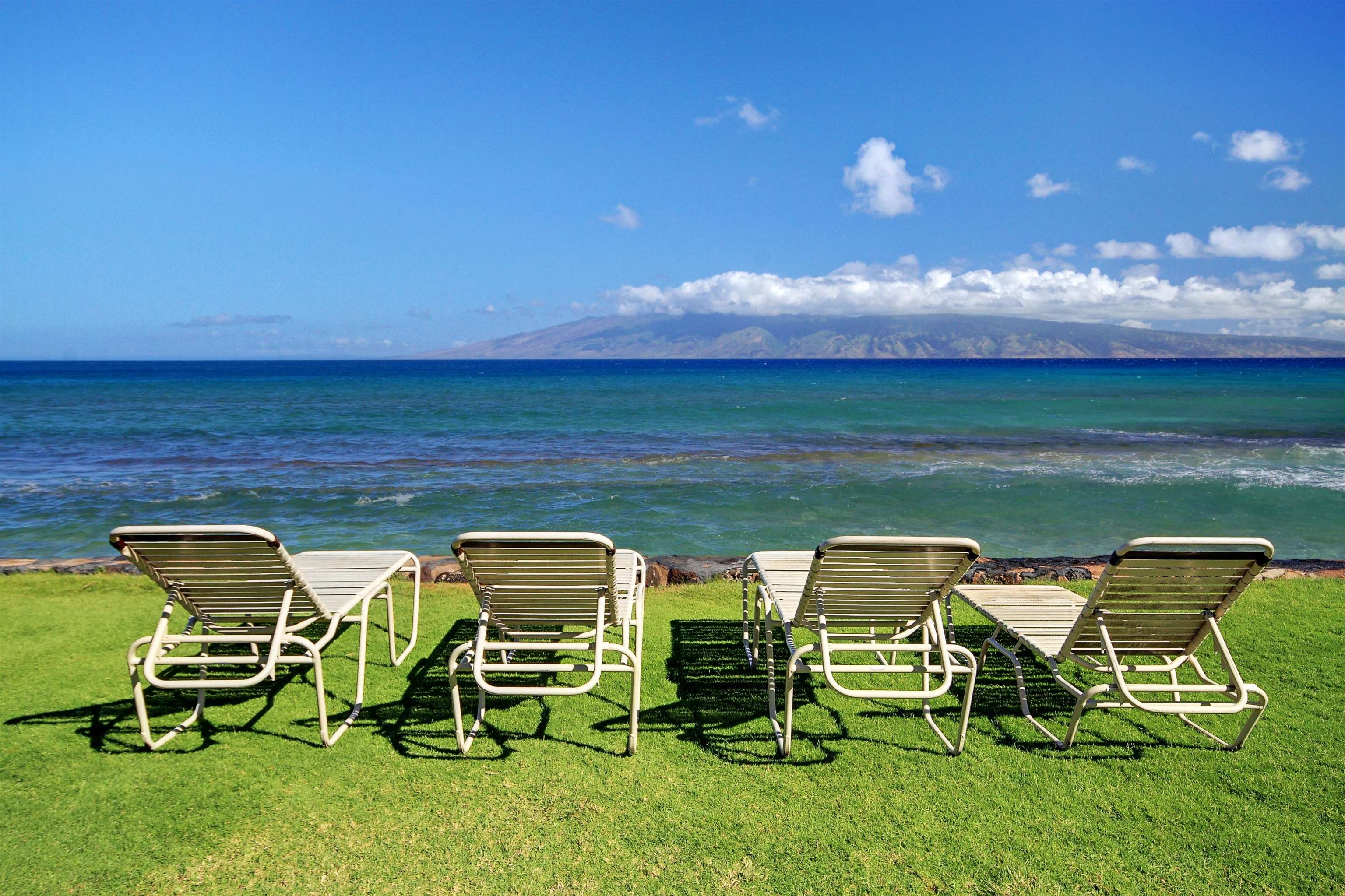 3543 Lower Honoapiilani Road, Unit K403 Lahaina, HI 96761 - Photo 25 of 29 a couple of chairs sitting in a backyard with swimming pool
