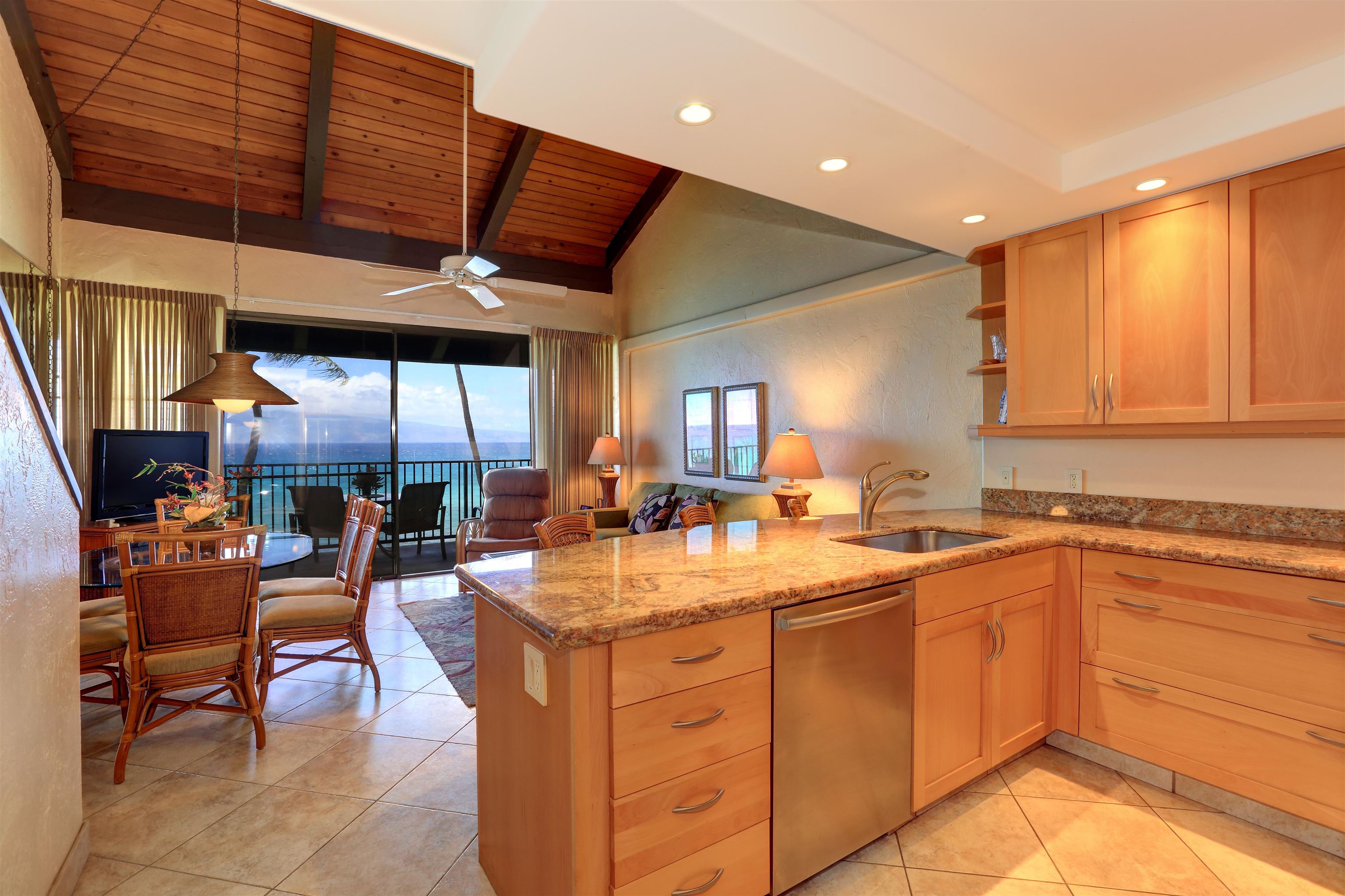 3543 Lower Honoapiilani Road, Unit K403 Lahaina, HI 96761 - Photo 4 of 29 a kitchen with a sink dining table and chairs