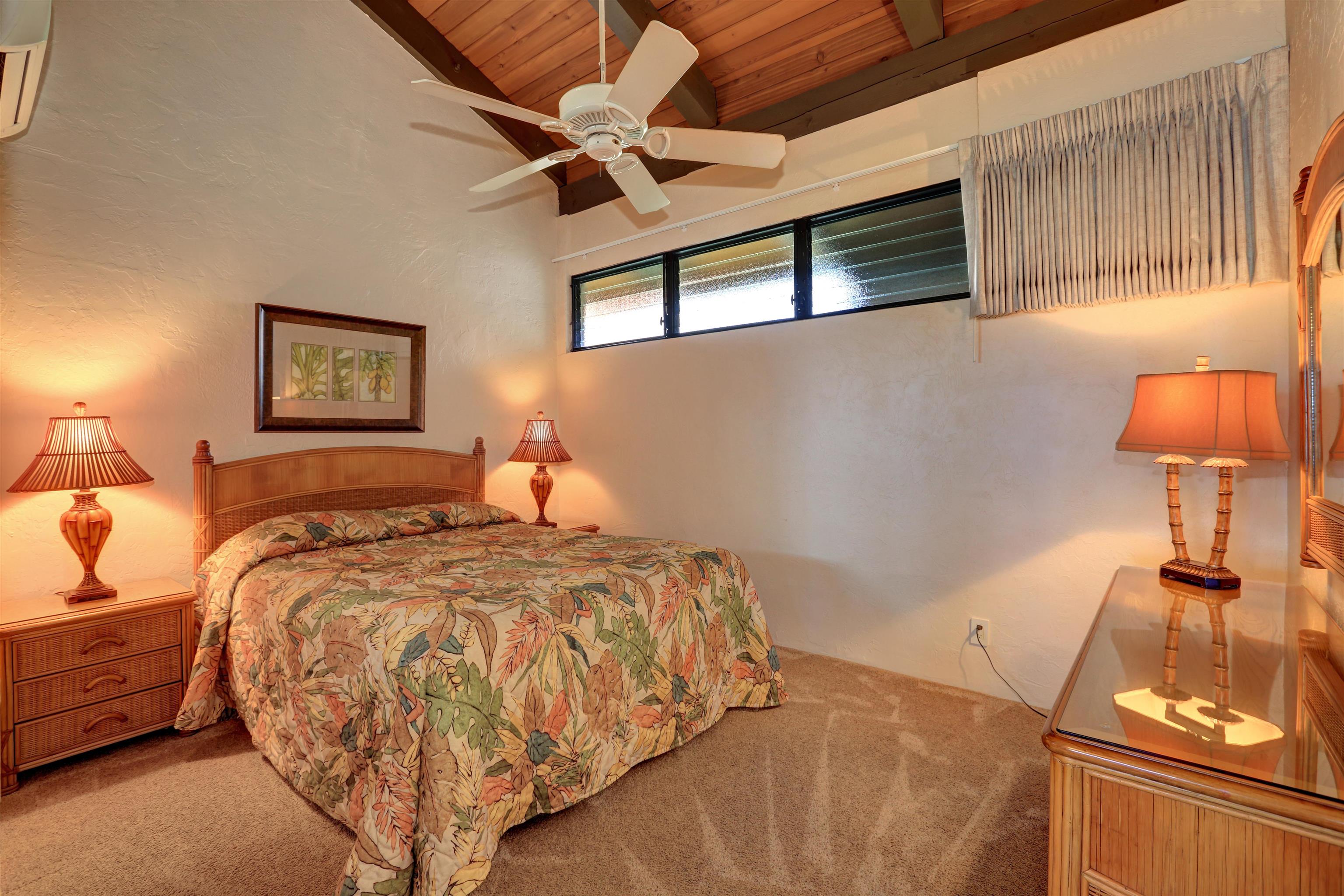 3543 Lower Honoapiilani Road, Unit K403 Lahaina, HI 96761 - Photo 5 of 29 a bed sitting in a bedroom next to a lamp