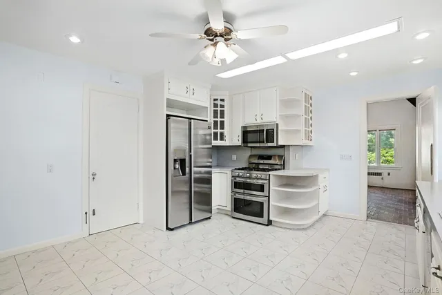 a view of kitchen with stainless steel appliances refrigerator cabinets and stove top oven