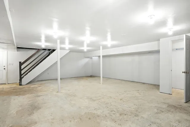 an empty room with staircase and white walls