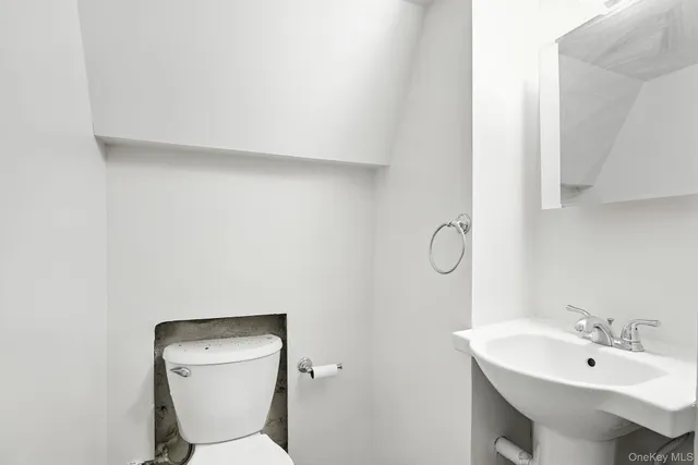 a bathroom with a toilet a sink and mirror