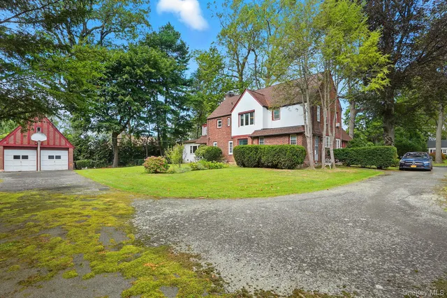a view of a house with a big yard and large trees