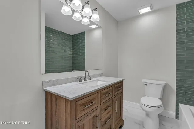 a bathroom with a sink a toilet and a mirror