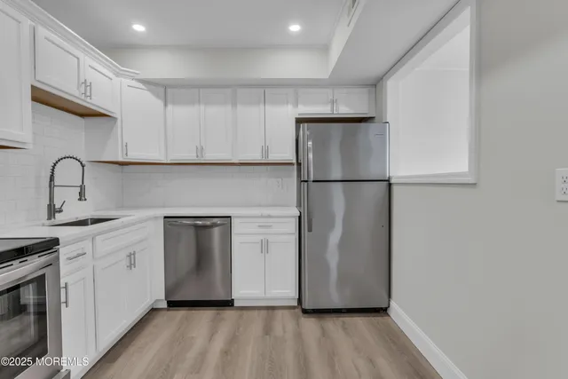 a kitchen with a refrigerator sink and cabinets