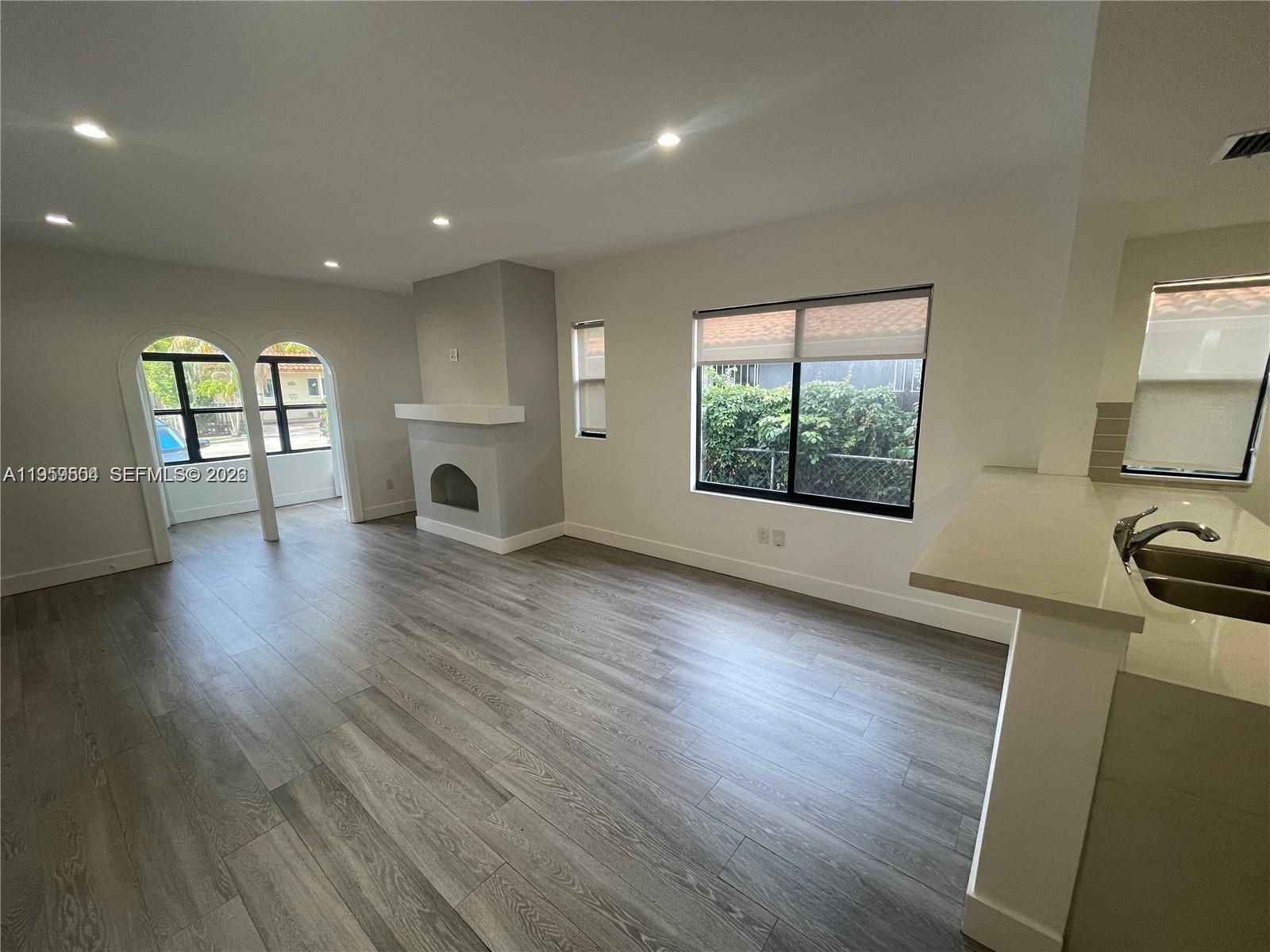 1637 Southwest 10th Street, Unit 2 Miami, FL 33135 - Photo 2 of 9 a view of an empty room with wooden floor and a window