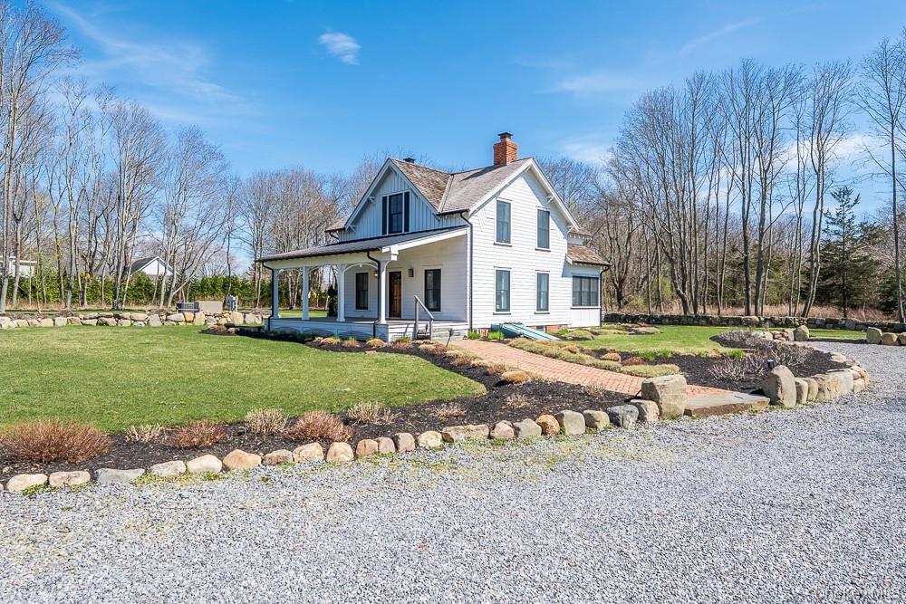19000 Main Road Mattituck, NY 11952 - Photo 3 of 32 View of home's exterior featuring a chimney, covered porch, a lawn, and a shingled roof