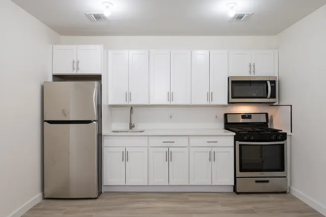 a kitchen with a refrigerator sink and cabinets