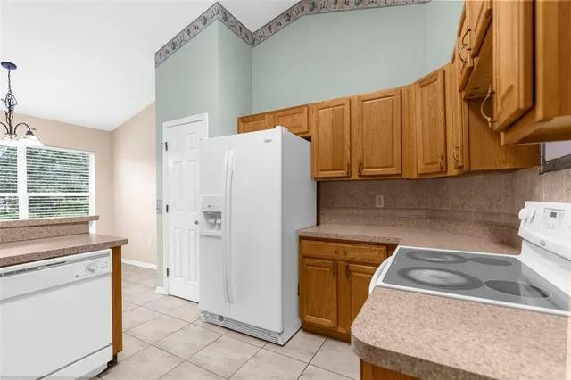 a kitchen with a refrigerator sink and cabinets