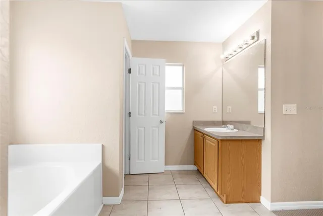 a bathroom with a tub sink and mirror