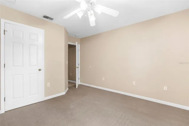 an empty room with a ceiling fan and a window