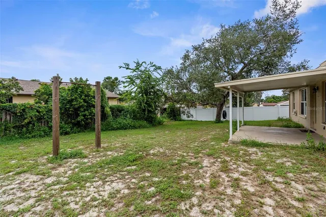 a view of a house with backyard and a tree