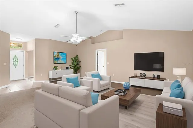 a living room with furniture a flat screen tv and a chandelier